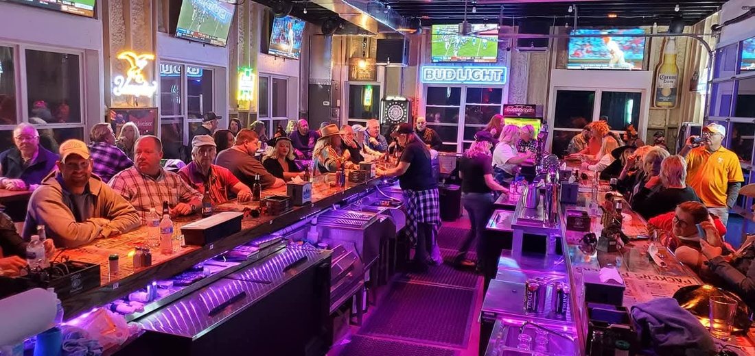 Crowded night at the bar with neon signs and TVs