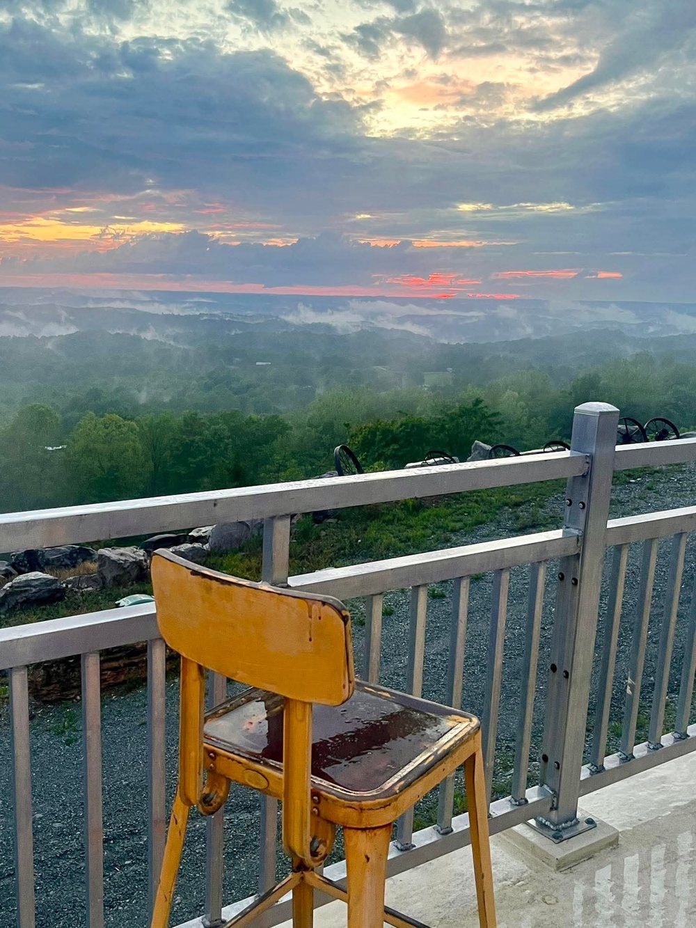 Vintage yellow chair on the deck railing at sunset